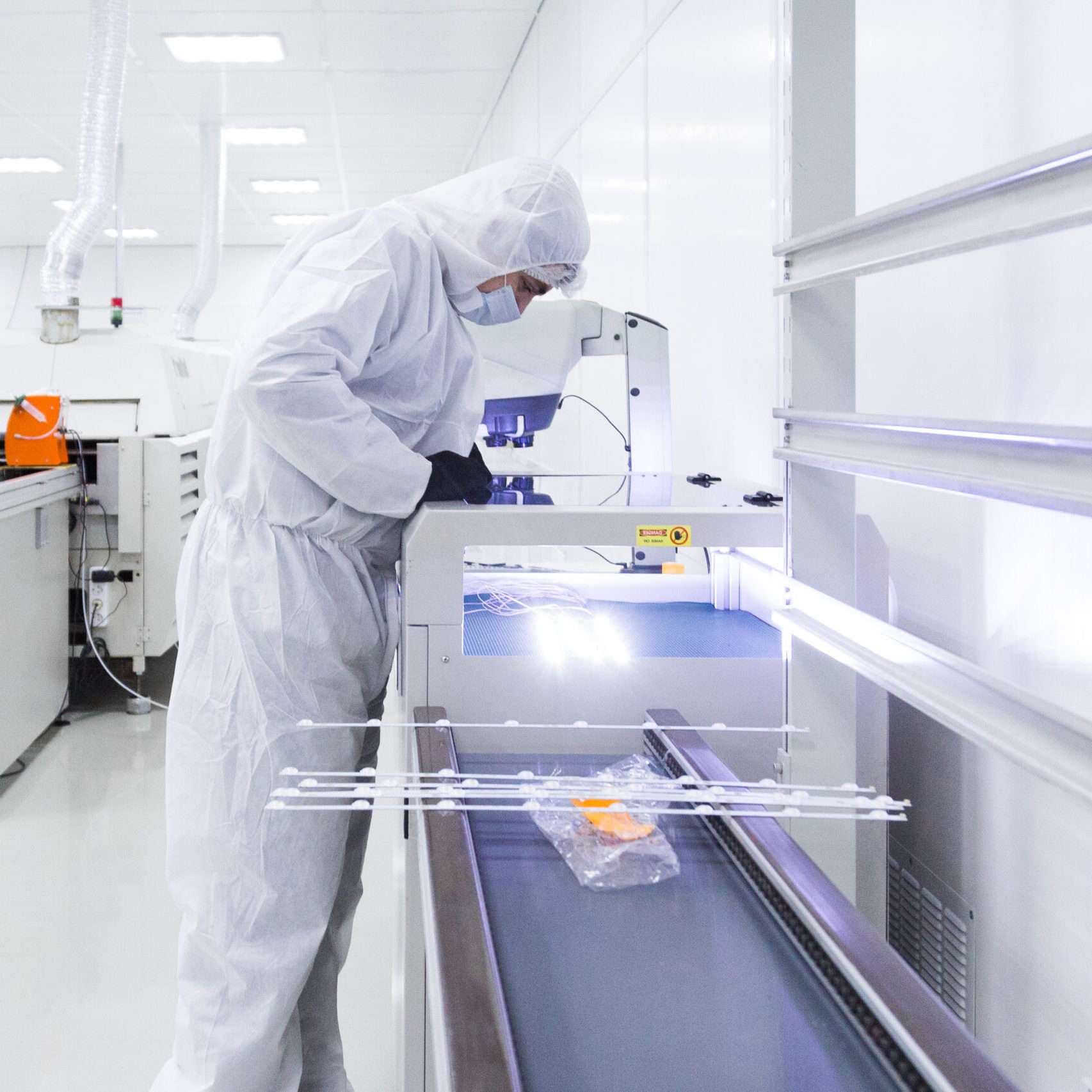 people in white isolating costumes working in laboratory